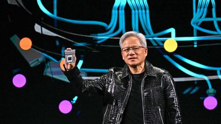 Le PDG de Nvidia, Jensen Huang, tient un processeur Drive Thor de Nvidia lors de son discours d'ouverture au Consumer Electronics Show (CES) à Las Vegas, le 6 janvier 2025 (PATRICK T. FALLON / AFP)