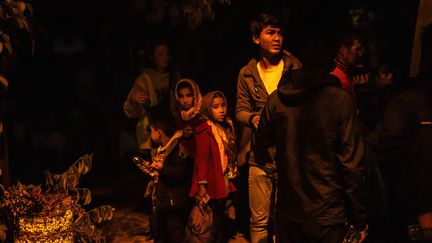 Des migrants attendent lors d'un transfert, sur l'île de Lesbos, le 2 octobre 2019. (ANGELOS TZORTZINIS / AFP)