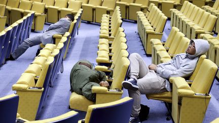 Des journalistes s'accordent une petite sieste en marge des discussions, dimanche 12 juillet &agrave; Bruxelles (Belgique).&nbsp; (FRANCOIS LENOIR / REUTERS)