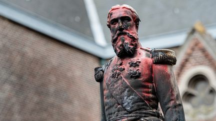 Une statue du roi Léopold II de Belgique, le 4 juin 2020 à Anvers, teintée de rouge après avoir été dégradée la nuit précédente.&nbsp; (JONAS ROOSENS / BELGA / AFP)