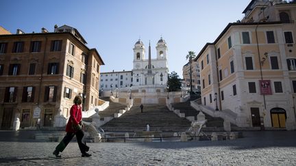 Une femme traverse la Piazza di Spagna à Rome, dimanche 15 mars 2020 à Rome (Italie). (CHRISTIAN MINELLI / NURPHOTO / AFP)