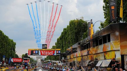 Le peloton passe sur les Champs-Elysées, salué par la patrouille de France avec l'Arc de Triomphe en ligne de mire