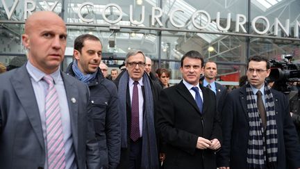 Le ministre de l'Int&eacute;rieur Manuel Valls, &agrave; c&ocirc;t&eacute; du maire PS d'Evry Francis Chouat (c), lors d'un d&eacute;placement &agrave; Evry&nbsp;(Essonne), le 27 mars 2013. (MIGUEL MEDINA / AFP)