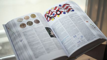 Une femme tient un exemplaire de l'édition 2015 du dictionnaire français "Petit Larousse", qui vient d'être imprimé, le 21 mai 2014 à Paris.&nbsp; (FRED DUFOUR / AFP)