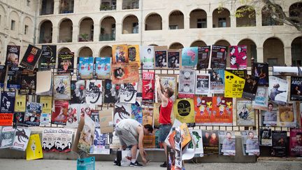 Artsites accrochant leurs affiches au Festival Off d'Avignon, le 7 juillet 2016 (BERTRAND LANGLOIS / AFP)