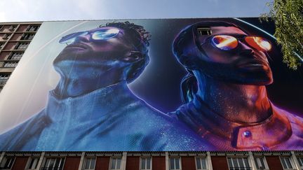 Le visuel de l'album "Deux frères" de PNL, sur un immeuble d'Ivry-sur-Seine, en 2019, où les deux artistes ont passé une partie de leur adolescence.&nbsp; (LIONEL BONAVENTURE / AFP)