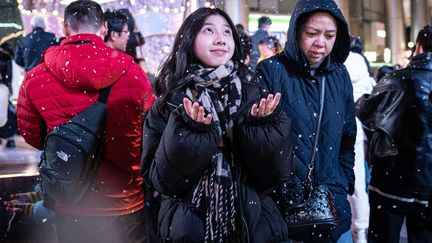 Il neige (pour de faux) dans le quartier d'affaires de Guangzhou, en Chine, où la neige artificielle a ravi les passants, le 24 décembre 2023. (AFP)