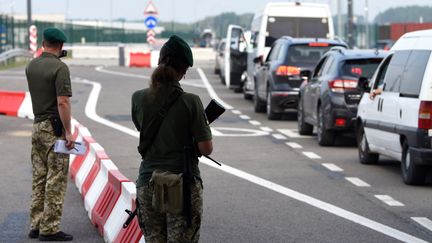 Des agents de contrôle à la frontière entre la Pologne et l'Ukraine, à Lviv (Ukraine), le 16 août 2022. (YURIY DYACHYSHYN / AFP)