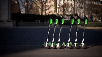 Des trottinettes électriques stationnées sur un trottoir, près de la tour Eiffel à Paris, le 13 décembre 2018. (LIONEL BONAVENTURE / AFP)