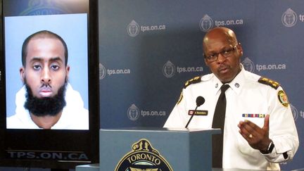 Mark Saunders, le chef de la police de Toronto (Canada), aux côtés du portrait de l'homme qui a agressé deux militaires canadiens. (COLIN PERKEL / AP / SIPA)