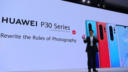 Richard Yu,&nbsp;directeur général de la branche grand public de Huawei présente de nouveaux smartphones P30 à Paris, le 26 mars 2019. (ERIC PIERMONT / AFP)