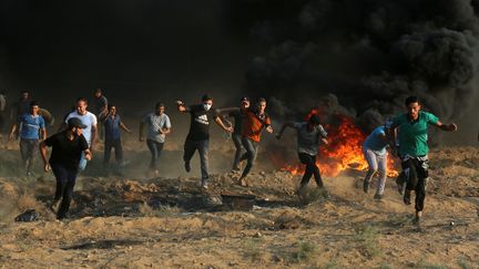 Des Palestiniens courent, lors d'une manifestation à Gaza, le 28 septembre 2018.&nbsp; (MAJDI FATHI / NURPHOTO / AFP)