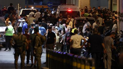 Des personnes se rassemblent à l'entrée du centre médical de l'Université américaine de Beyrouth, le 17 septembre 2024, après que des explosions ont touché des sites dans plusieurs bastions du Hezbollah au Liban. (ANWAR AMRO / AFP)