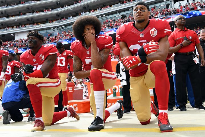 Harold (à gauche), Kaepernick (au centre) et Reid, genou à terre pendant l'Hymne nationale. (THEARON W. HENDERSON / GETTY IMAGES NORTH AMERICA)