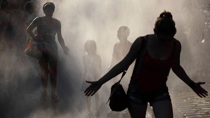 Des Parisiens se raffraichissent, le 20 juin 2019 à Paris Plage. (MANUEL COHEN / AFP)