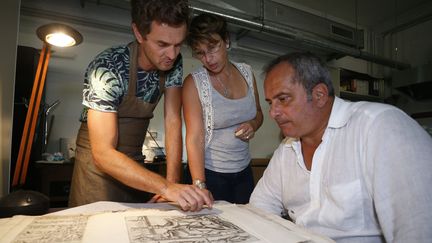 L'égyptologue italien Francesco Tiradritti (à droite), la responsable de la restauration et de la conservation des ouvrages de la bibliothèque d'Ajaccio, Vannina Schirinski-Schikhmatoff (au centre) et le conservateur italien Simone Martini observent une planche du "Thesaurus Hyeroglyphicorum" 
 (PASCAL POCHARD-CASABIANCA / AFP)