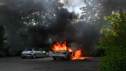 Une voiture brûle dans le quartier des Grésilles à Dijon (Côte-d'Or), le 15 juin 2020.&nbsp; (PHILIPPE DESMAZES / AFP)