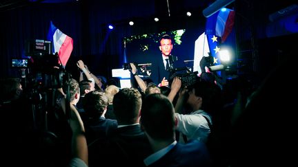 Des militants du Rassemblement national regardent Emmanuel Macron annoncer la dissolution de l'Assemblée nationale, à Paris, le 9 juin 2024. (DANIEL DORKO / HANS LUCAS / AFP)