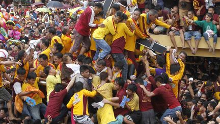 Des Chr&eacute;tiens s'entassent sur la statue du Nazar&eacute;en noir lors d'une procession dans les rues de Manille (Philippines), le 9 janvier 2013. (ROMEO RANOCCO / REUTERS)