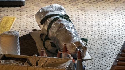 Une partie du "Pilier de la honte", une statue de l'artiste danois Jens Galschiot qui commémore les victimes de la répression de la place Tiananmen à Pékin en 1989, recouverte de plastique, à Hong Kong, le 23 décembre 2021. (YAN ZHAO / AFP)