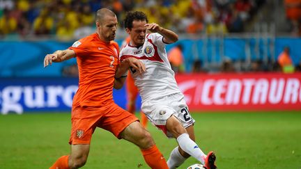 Le N&eacute;erlandais Ron Vlaar &agrave; la lutte avec le Costaricain Marco Urena, samedi 5 juillet &agrave; Salvador de Bahia, en quarts de finale de la Coupe du monde. (ODD ANDERSEN / AFP)