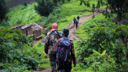 Deux rebelles du Mouvement du 23 mars (M23) marchant vers une position tenue par&nbsp;la rébellion&nbsp;sur la colline de Kavumu au Nord-Kivu, dans l'est de la République démocratique du Congo (RDC), le 3 juin 2012. (MELANIE GOUBY / AFP)