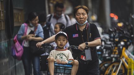 Des parents ramènent leurs enfants chez eux après l'école à Shanghai, en Chine, le 11 mai 2021. (ALEX PLAVEVSKI / EPA / MAXPPP)