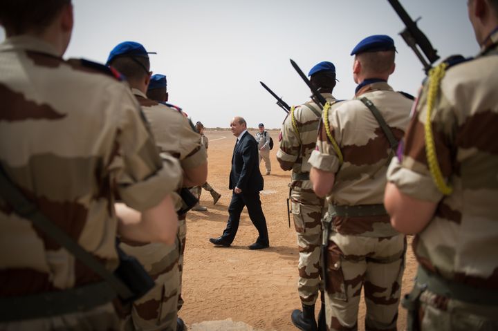 Jean-Yves Le Drian, alors ministre de la Défense, passe en revue les troupes françaises de l'opération Serval, le 26 avril 2013, à Gao&nbsp;au Mali. (MARTIN BUREAU / AFP)