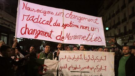 "Nous exigeons un changement radical du système non un changement de marionnettes", réclame une banderole des manifestants, le 11 mars 2019, à Alger. (ARSLANE BESTAOUI / SIPA)