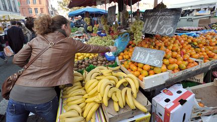 Une cliente s'empare de son sac d'achat sur un stand de fruits et légumes, le 20 novembre 2011 sur un marché à Lille. (PHILIPPE HUGUEN / AFP)