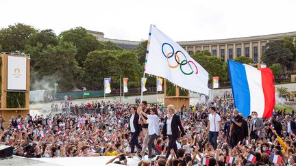 La maire de Paris Anne Hidalgo, le président du&nbsp;Cojop&nbsp;de Paris 2024 Tony Estanguet, l'ancienne ministre des Sports Roxana Maracineanu, et la présidente du CNOSF Brigitte Henriques, arrivent au Trocadéro à Paris, avec le drapeau olympique lors du retour des athlètes des Jeux olympiques de Tokyo, le 09 août 2021. (AGENCE KMSP / AFP)