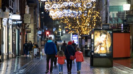 Une famille fait son shopping de Noël à Manchester, le 21&nbsp;décembre 2020, alors qu'un nouveau variant du coronavirus prolifère au Royaume-Uni depuis le mois de décembre. (MI NEWS / NURPHOTO / AFP)