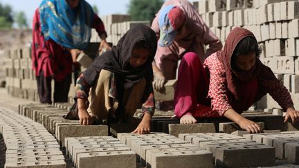 En Afghanistan, des petites filles en âge d'aller à l'école travaillent sur un chantier de briques, le 6 juin 2023  (illustration). (SHAFIULLAH KAKAR / AFP)