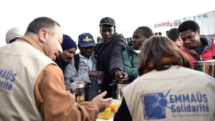 Des membres d'Emmaüs Solidarité&nbsp;distribuent de la nourriture lors d'une évacuation du campement de la Chapelle, à Paris, le 9 mai 2017. (PHILIPPE LOPEZ / AFP)