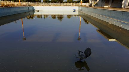 Une chaise entreposée dans une piscine déserte de l’ancien village olympique de Thrakomakedones, au nord d’Athènes, le 25 juillet 2014. Dix ans après les Jeux Olympiques d’été à Athènes, de nombreuses infrastructures olympiques, autrefois fastueuses, sont abandonnées ou utilisées très rarement pour des événements non sportifs, comme des conférences ou des mariages. (YANNIS BEHRAKIS / REUTERS)