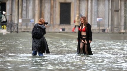 Une jeune femme pose au milieu de la place Saint-Marc inond&eacute;e &agrave; Venise (Italie), le 19 novembre 2013. (ANDREA PATTARO / AFP)