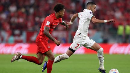 Hakim Ziyech échappe à Tajon Buchanan lors de la victoire du Maroc aux dépens du Canada, le jeudi 1er décembre 2022 à Doha. (FADEL SENNA / AFP)