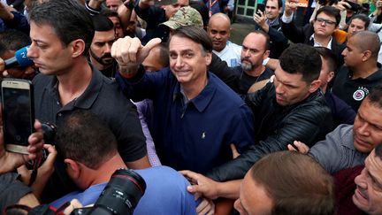 Jair Bolsonaro salue ses partisans après avoir voté au premier tour de la présidentielle, le 7 octobre 2018, à Rio de Janeiro (Brésil). (PILAR OLIVARES / REUTERS)