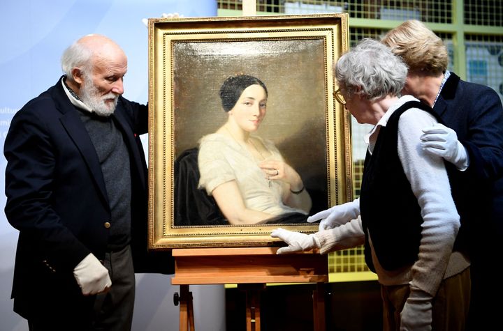 La ministre de la Culture allemande Monika Grütters lors de la restitution du tableau "Portrait de la jeune femme assise" de Thomas Couture, aux héritiers Maria de las Mercedes Estrada et Wolfgang Kleinertz, le 8 janvier 2019. (BRITTA PEDERSEN / DPA-ZENTRALBILD / AFP)