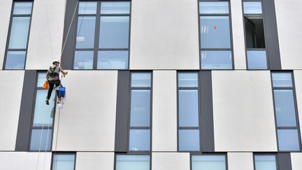 Nettoyage des vitres d'un immeuble de bureaux, à Nantes, en octobre 2017. (LOIC VENANCE / AFP)