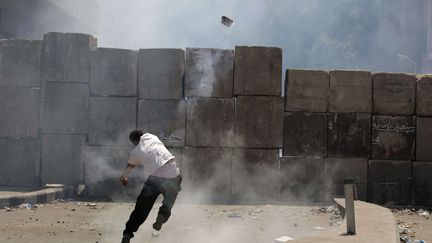 Un manifestant &eacute;gyptien retourne &agrave; la police une grenade lacrymog&egrave;ne lors d'affrontement aux abords de l'ambassade am&eacute;ricaine au Caire (Egypte), le 14 septembre 2012. (NASSER NASSER / AP / SIPA)