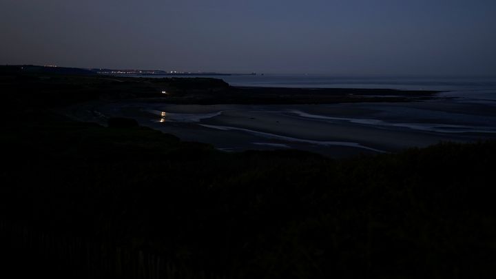 Une voiture de police surveille&nbsp;une plage de Wimereux (Pas-de-Calais), tôt le matin du 21 septembre 2021. (PIERRE-LOUIS CARON / FRANCEINFO)