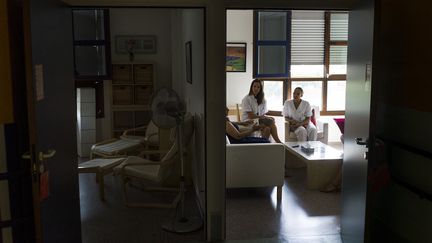 La famille d'un patient en soins palliatifs à l'hôpital d'Argenteuil (Val-d'Oise) rencontre un médecin et une psychologue, le 22 juillet 2013.&nbsp; (FRED DUFOUR / AFP)