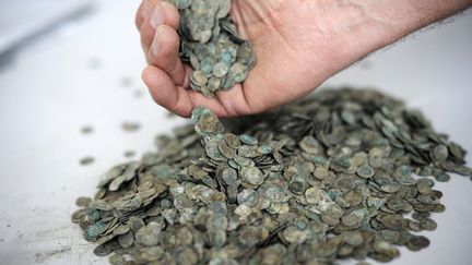 Des pièces de monnaie en bronze datant de l'époque romaine retrouvées à Sennecey-les-Dijon (Côte-d'Or), le 3 décembre 2010. (JEFF PACHOUD / AFP)