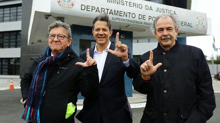 Jean-Luc Mélenchon (à gauche), aux côtés d'anciens&nbsp;ministre brésiliens de l'Education, Fernando Haddad (centre) et Aloizio Mercadante (droite), devant les locaux de la police de Curitiba (Brésil), le 5 septembre 2019. Ils font le signe "L", en soutien à l'ex-président du Brésil&nbsp;Luiz Inacio Lula da Silva.&nbsp; (HEULER ANDREY / AFP)