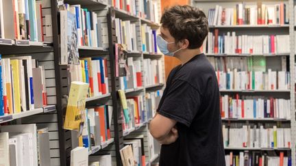 Image d'illustration. Un jeune homme choisi un livre dans une librairie à Lorient en août 2020. (MAUD DUPUY / HANS LUCAS)