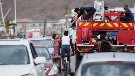 Les pompiers distribuent de l'eau aux habitants du quartier de&nbsp;Sandy Ground, à Saint-Martin, le 10 septembre 2017. (MARTIN BUREAU / AFP)