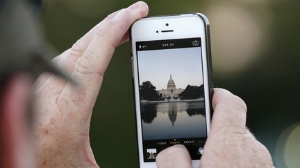 Un homme photographie le Capitole, &agrave; Washington, avec son iPhone, le 30 septembre 2013. (KEVIN LAMARQUE / REUTERS)