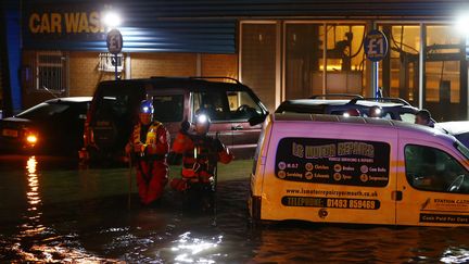 Les sauveteurs interviennent dans une station de lavage inond&eacute;e &agrave; Great Yarmouth, dans le sud-est de l'Angleterre, le 6 d&eacute;cembre 2013. Ils&nbsp;v&eacute;rifient l'int&eacute;rieur des voitures pour &eacute;ventuellement venir en aide &agrave; des gens coinc&eacute;s. (DARREN STAPLES / REUTERS)