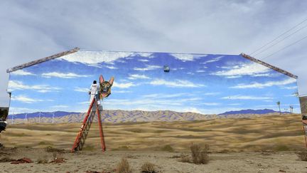 L'artiste John Coleman peint le mur d'une clinique v&eacute;t&eacute;rinaire &agrave; Hot Springs (Californie, Etats-Unis), le 2 d&eacute;cembre 2013. (KEVORK DJANSEZIAN / REUTERS)